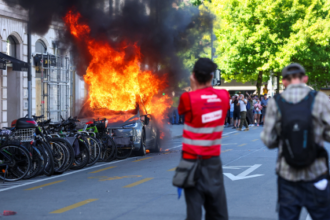 Anti-G7 protest turns violent as demonstrators torch Tesla and smash UN office windows