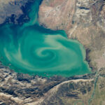 Giant, milky-green vortex swirls across massive ‘cryptodepression’ lake in Southern Europe — Earth from space